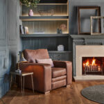 Sloane leather armchair next to a fireplace