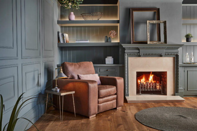Sloane leather armchair next to a fireplace